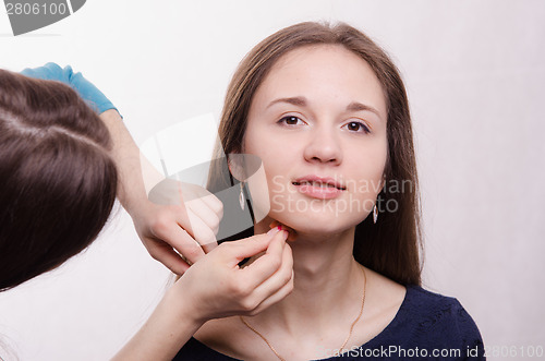 Image of Beautiful model is applied concealer on neck