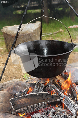 Image of big metal pot on camp fire