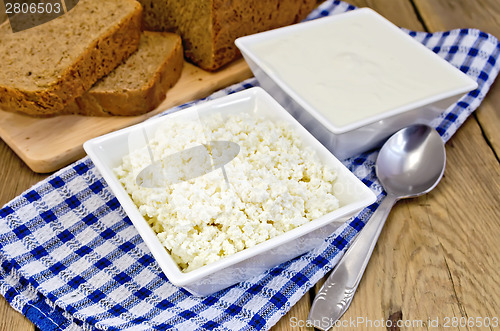 Image of Curd and sour cream in bowls on board with bread