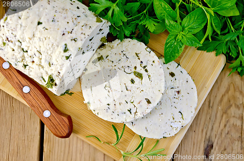 Image of Cheese homemade with herbs and knife on board