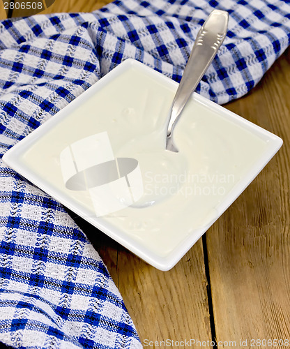Image of Sour cream with a spoon on board