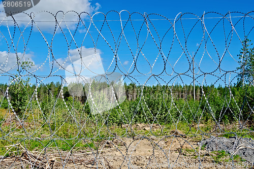 Image of Barbed wire fence with blue sky
