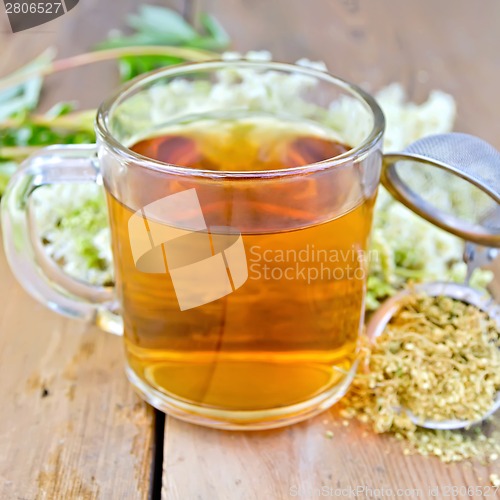 Image of Herbal tea from meadowsweet dry in mug with strainer