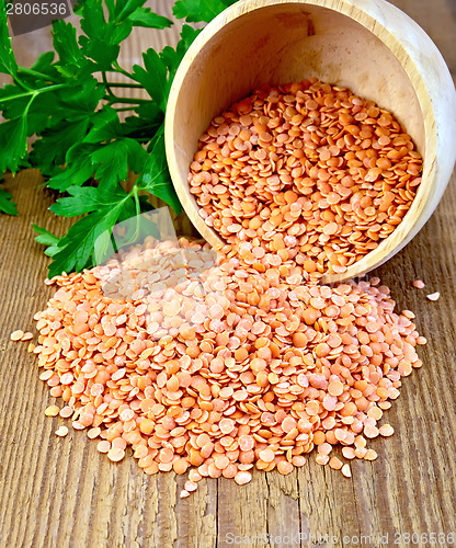Image of Lentils red in wooden bowl on board