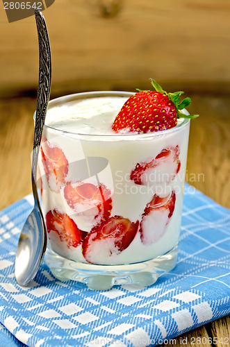 Image of Yogurt thick with strawberries and spoon on board