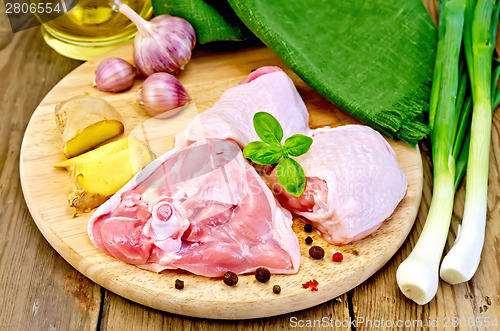 Image of Chicken thigh sliced with onions on board