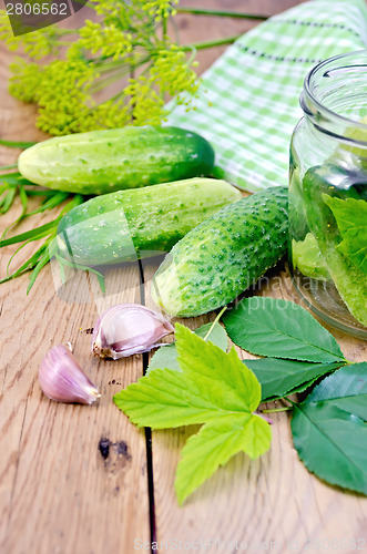 Image of Cucumbers with jar and garlic on board