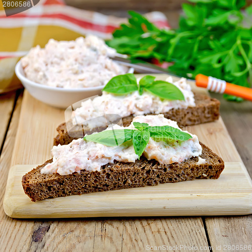 Image of Sandwich with cream of salmon and knife on board