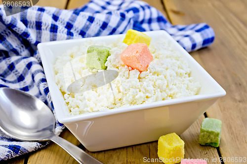 Image of Curd with colored sugar and spoon on board