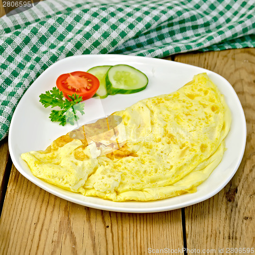 Image of Omelet with vegetables and green napkin on board