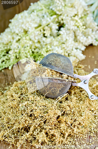 Image of Herbal tea from dry meadowsweet in strainer on board