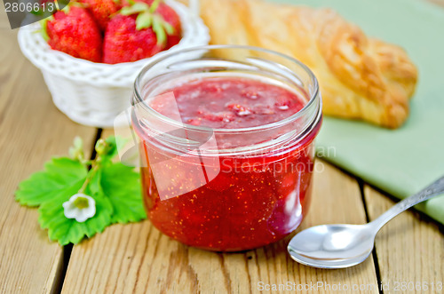 Image of Jam of strawberry with bun and basket on board