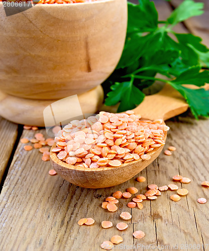 Image of Lentils red in wooden utensil on board