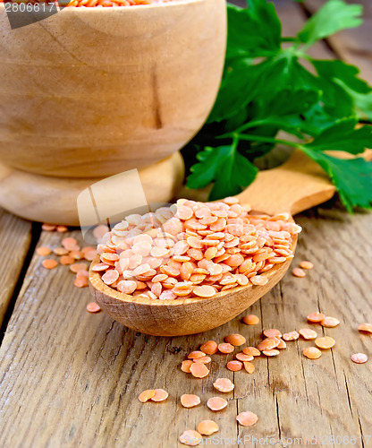 Image of Lentils red in wooden utensil on board