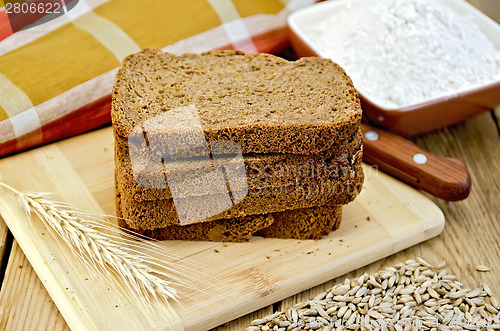 Image of Rye bread with flour and grain on board