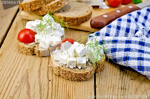 Image of Bread with feta and tomatoes on board with napkin