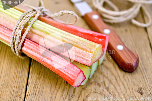 Image of Rhubarb with twine and knife on board