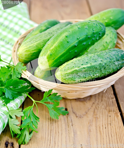 Image of Cucumbers in wicker basket on board