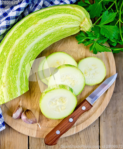 Image of Zucchini green with garlic and knife on board