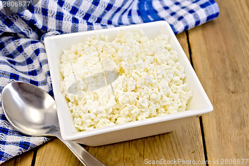 Image of Curd with blue napkin and spoon on board