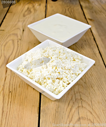 Image of Curd and sour cream in bowls on board