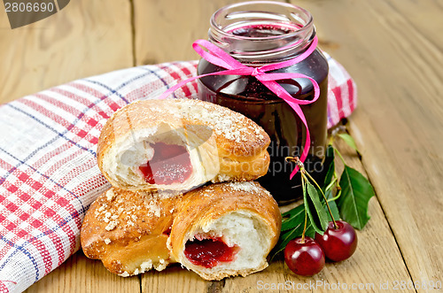 Image of Bun with cherry jam and berries on board