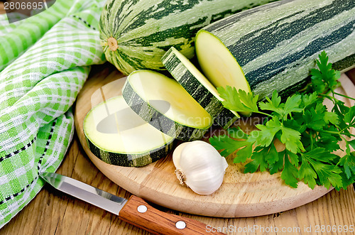 Image of Zucchini green striped with garlic on a board