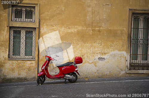 Image of Bright red Vespa scooter in an urban street