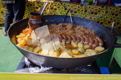 Image of Potatoes, sausage cabbage meal baked in a huge pan 