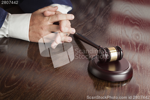 Image of Judge Rests Hands Behind Gavel with American Flag Table Reflecti