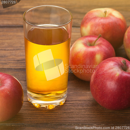 Image of Glass of apple juice and red apples on wood