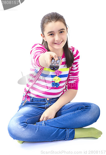 Image of Happy little girl laying down and watching tv