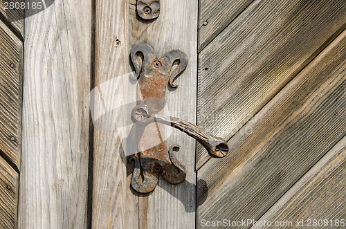 Image of ancient manor door handle on old wooden door 