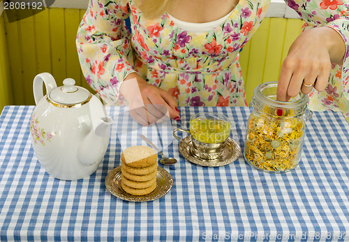 Image of hand prepare marigold herb tea 