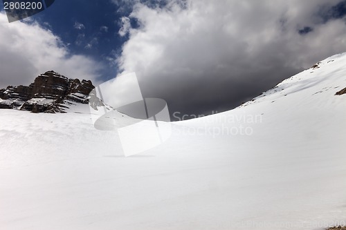 Image of Snowy mountain pass and sky with storm clouds