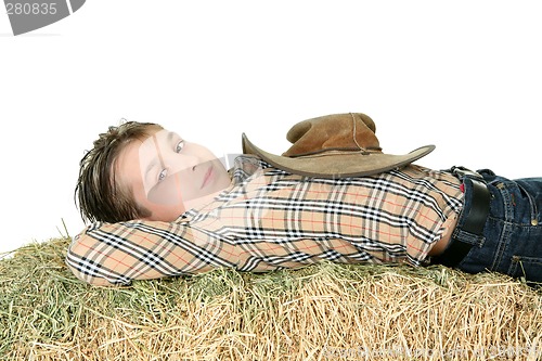 Image of Country boy resting on hay