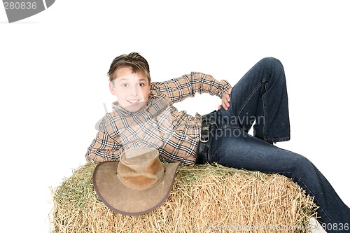 Image of Rural child lying on hay bale