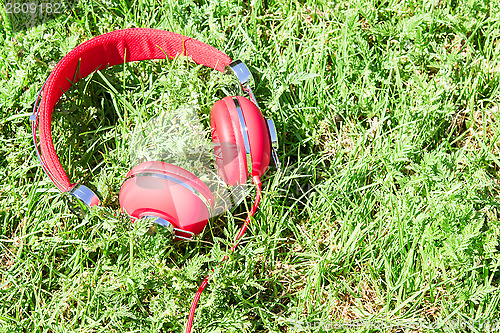 Image of Vibrant red headphones on fresh glade