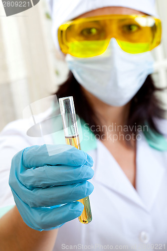 Image of woman doctor shows a test tube of yellow solution