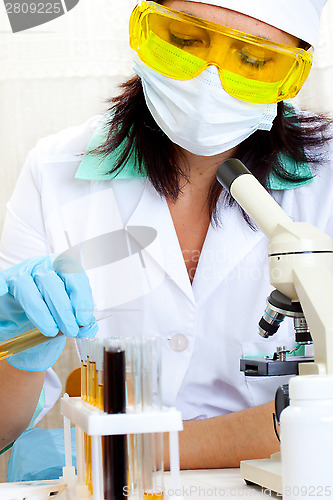 Image of doctor looking at a test tube of yellow solution