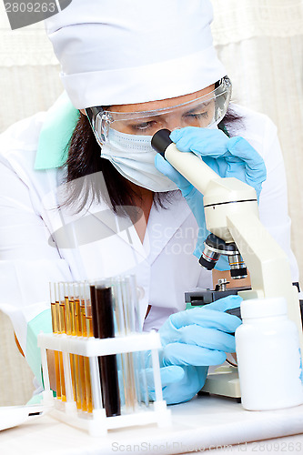 Image of doctor looking at a test tube of yellow solution