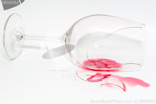 Image of Shattered snifter glass with splattered spilt red wine