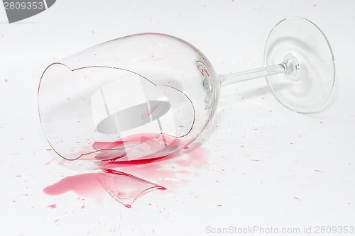 Image of Broken wineglass with spilled splash of red wine