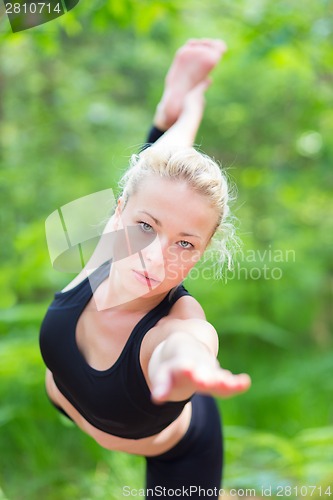 Image of Woman practicing yoga in the nature.