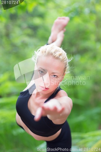 Image of Woman practicing yoga in the nature.