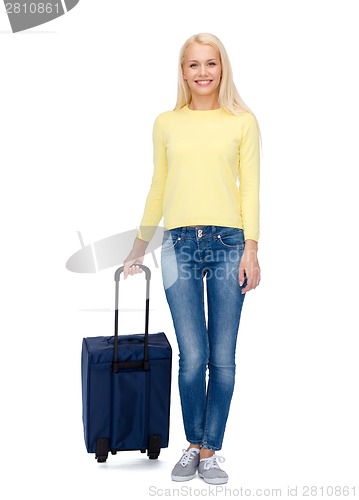 Image of smiling young woman with suitcase