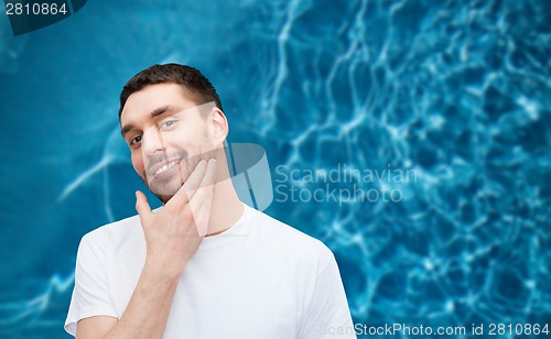 Image of beautiful smiling man touching his face