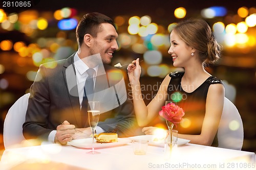 Image of smiling couple eating dessert at restaurant