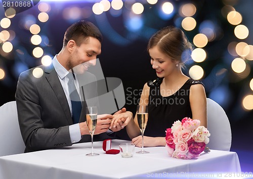 Image of man proposing to his girlfriend at restaurant