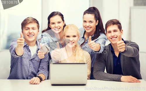 Image of smiling students with laptop showing thumbs up